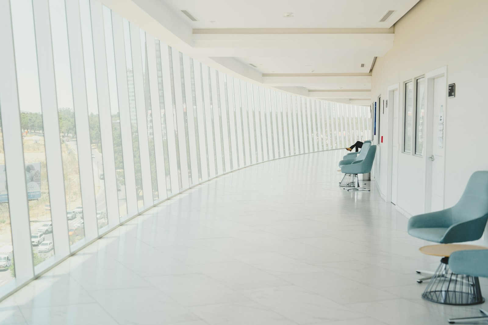 A clinic corridor with a row of waiting chairs — the empty seats VIGIL fills