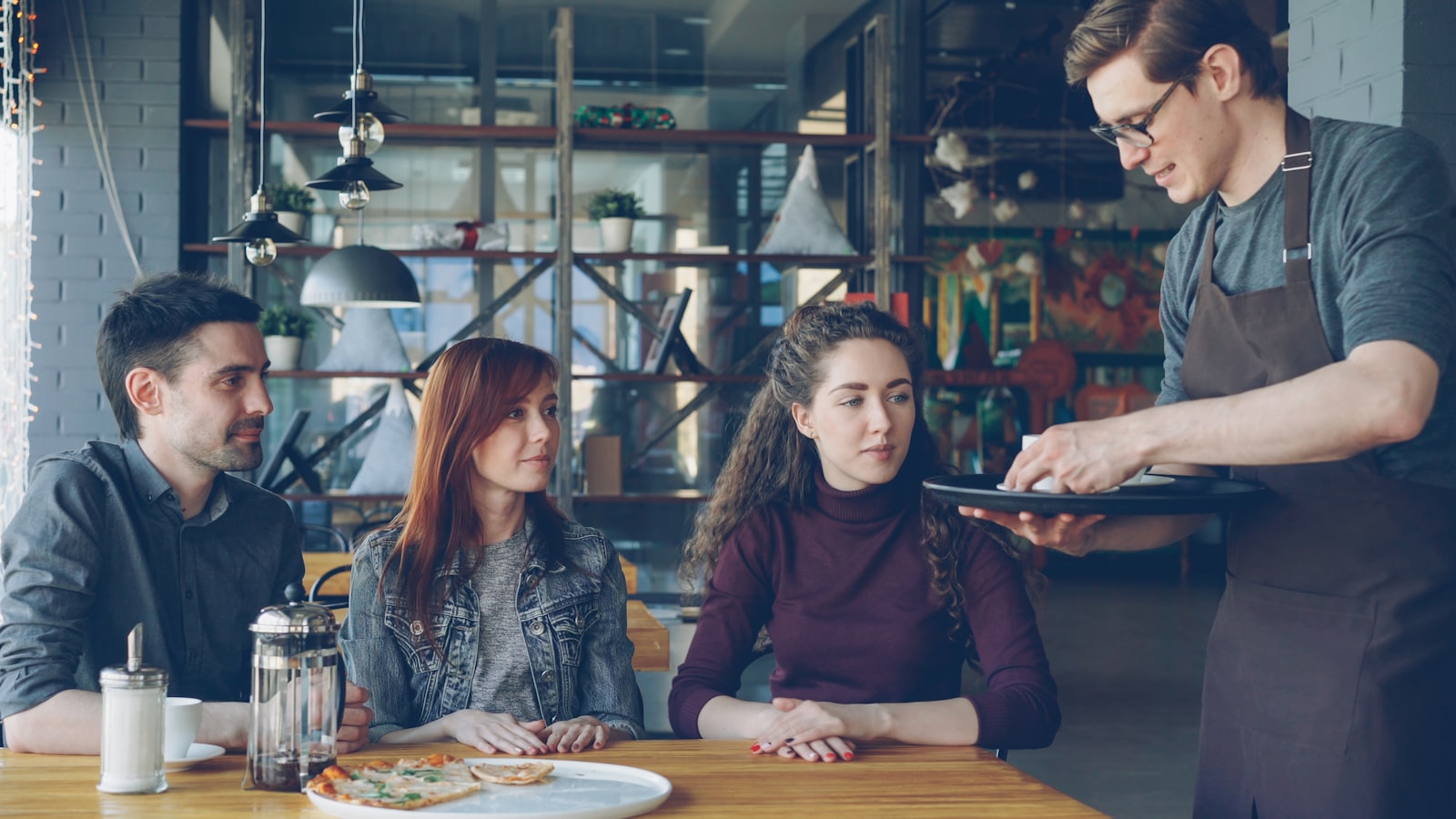 A waiter serving a table — the front-of-house flow F&B POS runs